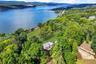 Drone / aerial view of a heavily wooded area and a water and mountain view