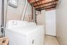 Dedicated laundry area featuring a tile floor, white appliances, and a paneled door