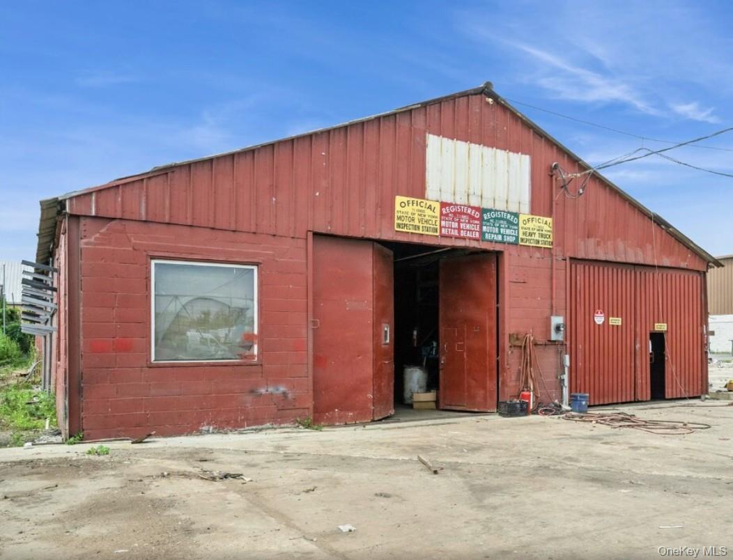 View of building exterior featuring a garage and an outbuilding