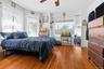 Spacious first-floor bedroom featuring hardwood flooring and ample room for a dedicated workspace or reading nook.