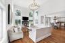 Two-story living area with hardwood flooring, a fireplace featuring a dark mantel, and multiple arched windows