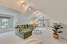 Carpeted living room with lofted ceiling and rail lighting