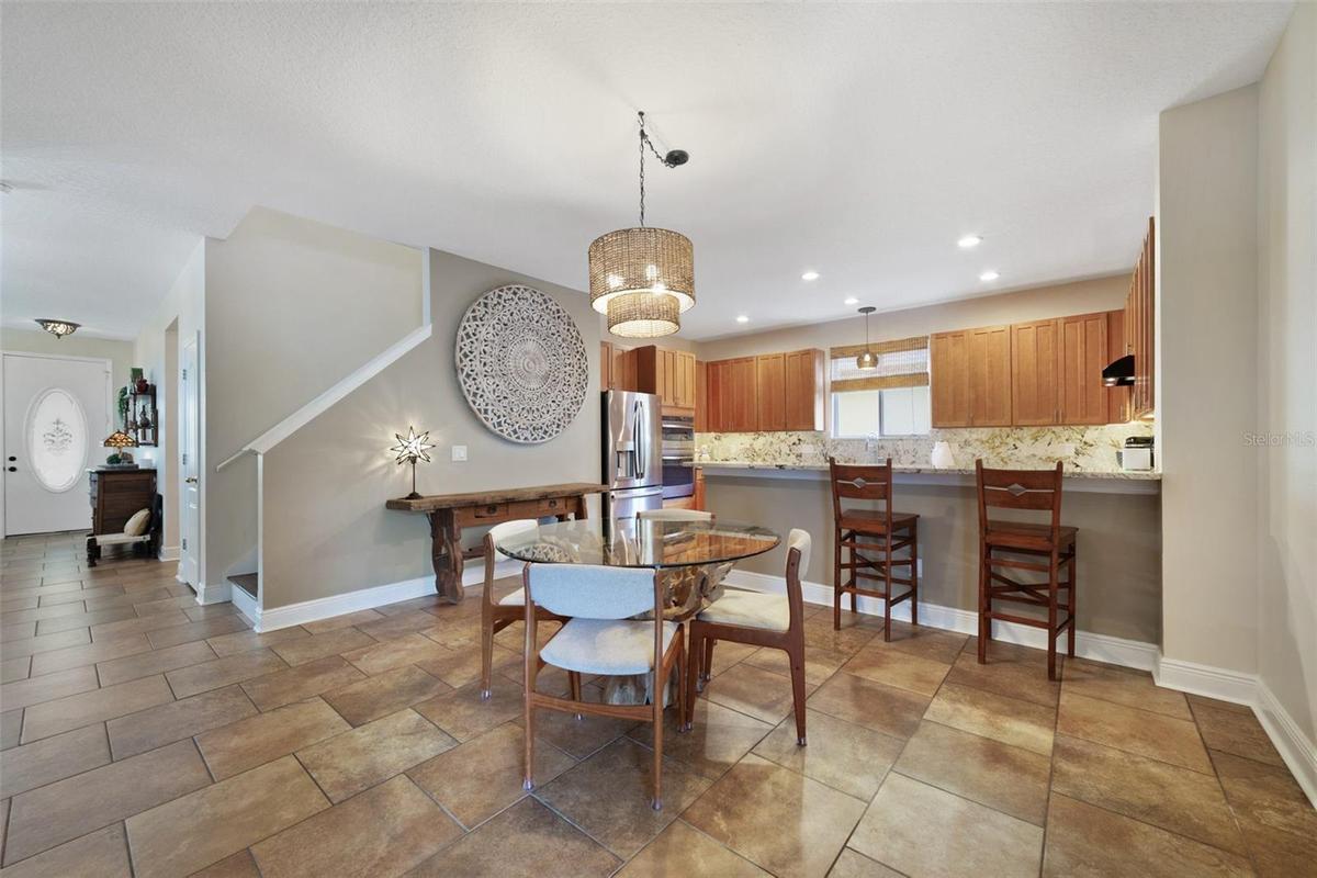 The kitchen is designed to be the heart of the home, featuring sleek granite countertops that continue into the backsplash, ample cabinet storage, bre