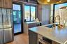 Kitchen featuring wine cooler, stainless steel refrigerator, light countertops, light wood-style floors, and a sink