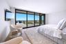 Bedroom with floor to ceiling windows, wood finished floors, and access to outside