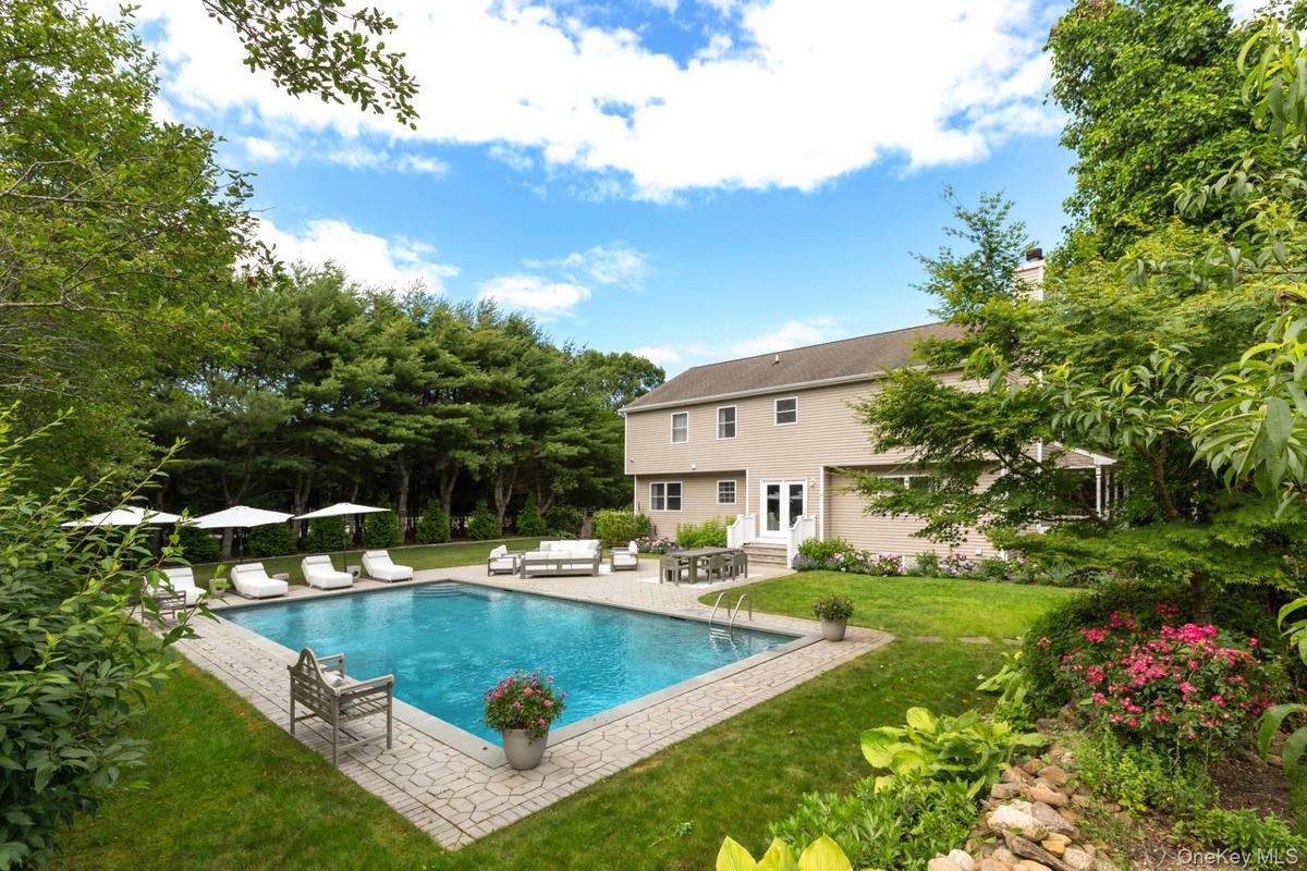 Swimming pool with a yard, a patio area, entry steps, and an outdoor living space