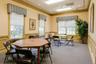 Dining space in the clubhouse with crown molding, a decorative wall, light carpet, recessed lighting, and wainscoting