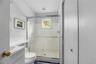 Full bath featuring vanity, a shower stall, and a wainscoted wall