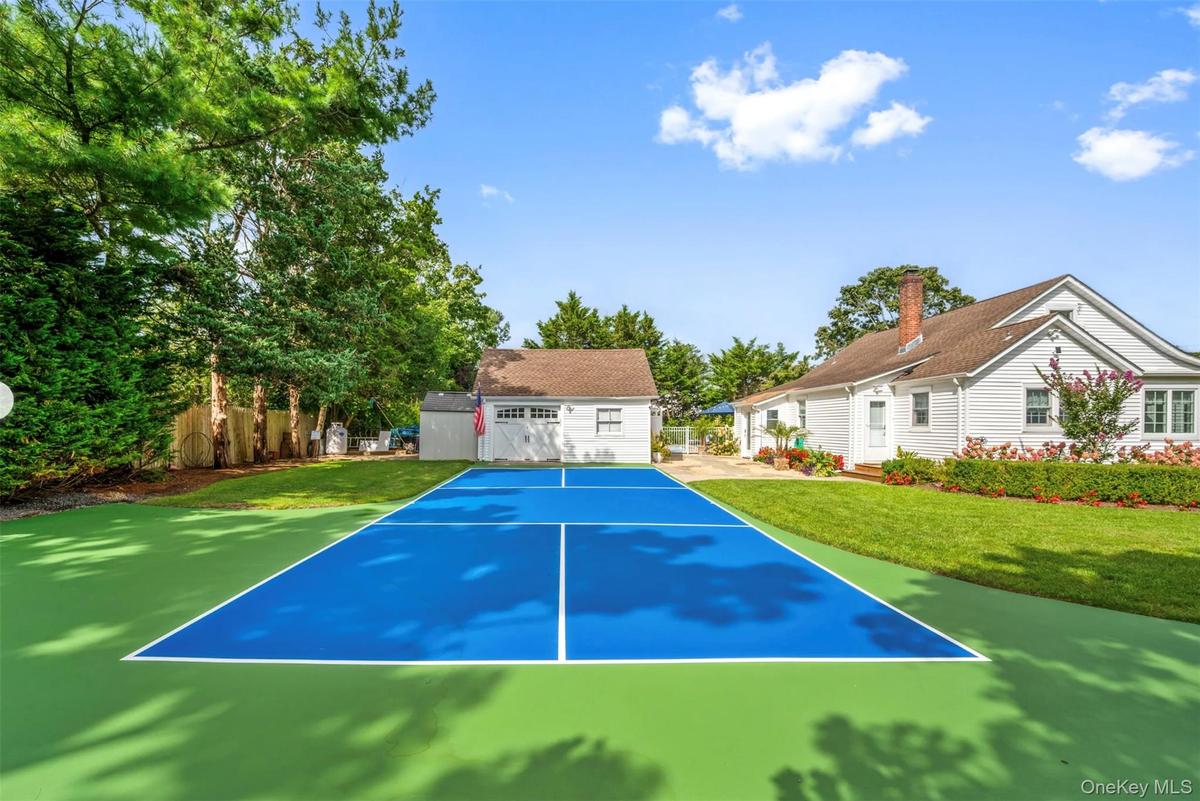 View of sport court with a lawn
