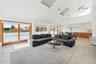 Living room with high vaulted ceiling, ceiling fan, and a healthy amount of sunlight