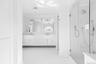 Full bath with double vanity, ornamental molding, and a shower stall