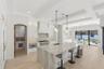 Kitchen features crystallized quartzite counters, oversized waterfall island & walk-in panty