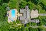 Expansive estate featuring a large main residence, a substantial swimming pool with integrated spa, a pool house, a circular driveway, and extensive m