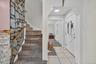 Foyer entrance featuring light tile patterned floors, light colored carpet, a baseboard heating unit, stairs, and arched walkways