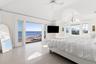 Bedroom with access to exterior, multiple windows, a chandelier, high vaulted ceiling, and a ceiling fan