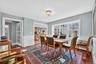Dining space with wainscoting, dark wood finished floors, and a decorative wall