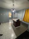 Kitchen featuring a baseboard radiator, a center island, decorative light fixtures, a chandelier, and light tile patterned flooring