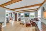 Living area featuring beam ceiling and light wood-style flooring