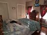 Bedroom featuring a wall mounted air conditioner, hardwood / wood-style flooring, a baseboard radiator, and a closet