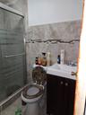 Full bath featuring vanity, a shower stall, tile walls, and tile patterned floors