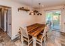 Tiled flooring throughout, featuring a dining area with two pendant lights and open shelving