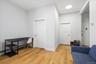 1st Floor Apartment entry into living room and doors to 2 bedrooms; features light hardwood floors and white walls, offering a bright and versatile en