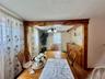 0 - Dining space with a notable chandelier, wood finished floors, baseboard heating, baseboards, and beamed ceiling