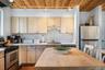 Kitchen featuring a wood-panel ceiling with track lighting, light-toned cabinetry, stainless steel appliances, a built-in dishwasher, and a wood-finis