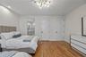 Bedroom with light wood-style flooring, a chandelier, and ensuite bathroom
