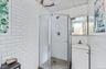 Full bathroom with tile walls, a stall shower, and vanity