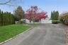 View of front facade featuring a front yard, driveway, and a garage