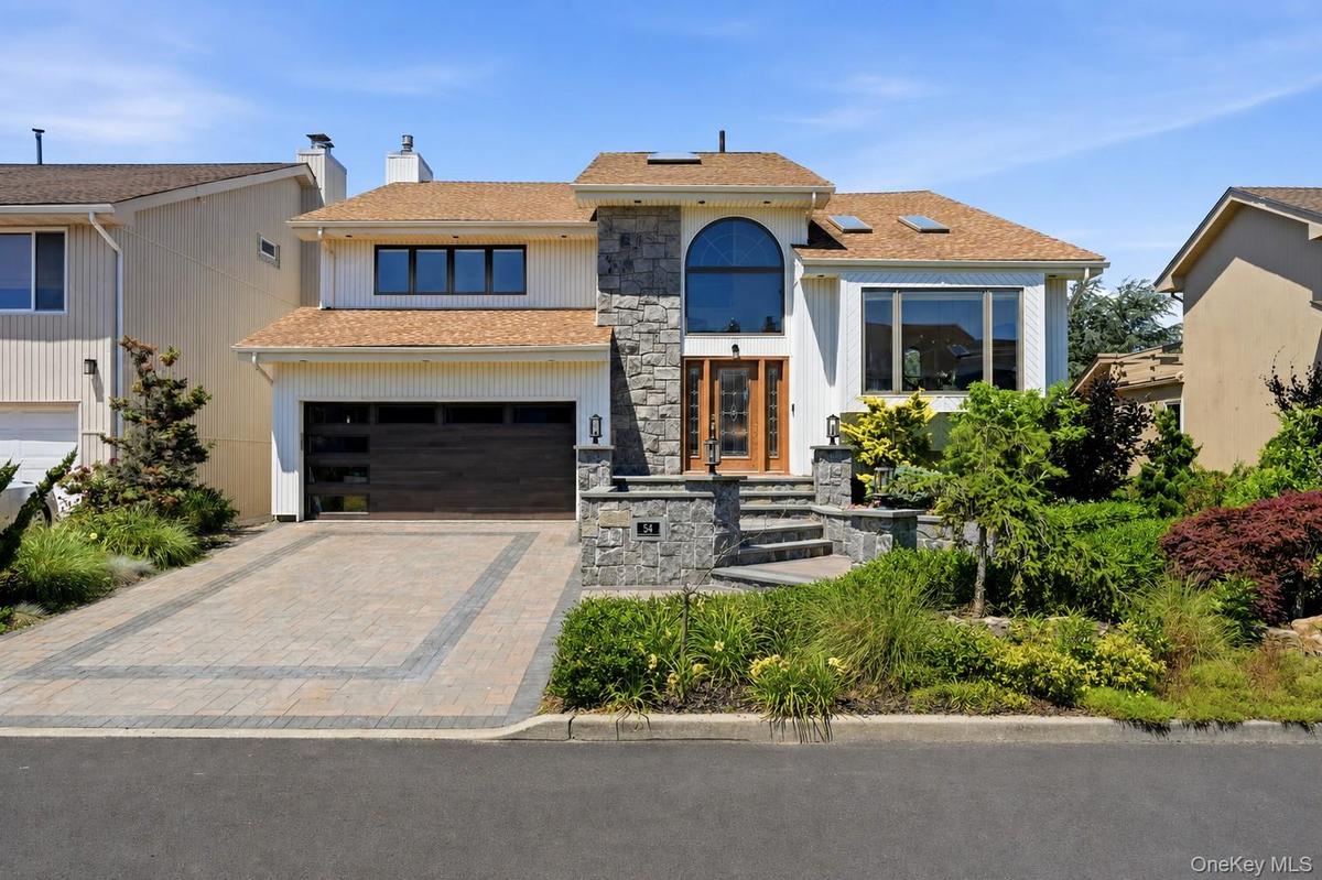 Contemporary residence featuring a stone facade and white siding