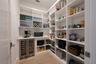 Adjacent to the kitchen, a walk-in pantry offers additional luxury and convenience with custom shelving, beverage refrigerator, and electrical outlets