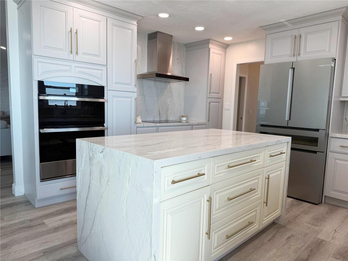 Updated kitchen featuring a quartz waterfall island and contemporary cabinetry.