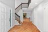 Entrance foyer with light wood-style flooring, baseboards, recessed lighting, stairway, and a stone fireplace