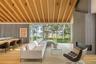 Living area featuring a large fireplace, a water view, light wood-type flooring, and a wood ceiling with exposed beams