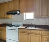 Kitchen featuring white gas stove, island range hood, and backsplash
