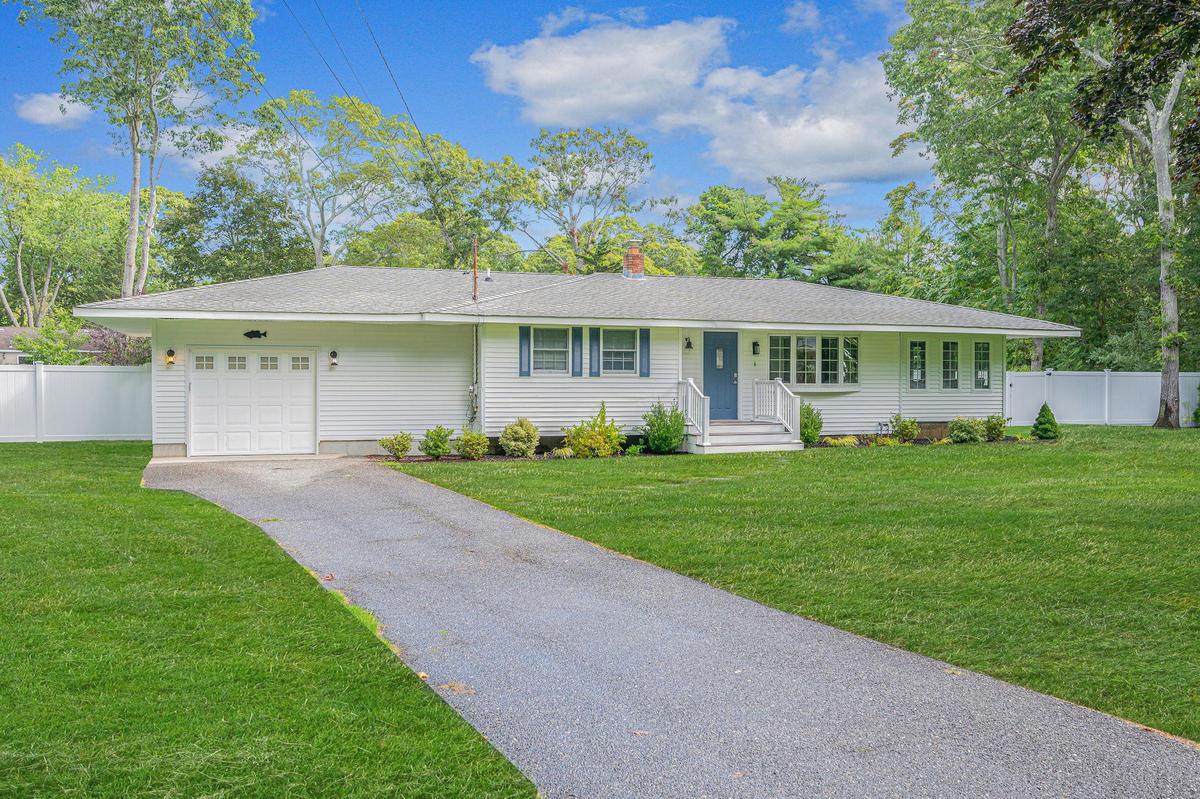 Ranch-style home with a chimney, an attached garage, roof with shingles, and asphalt driveway