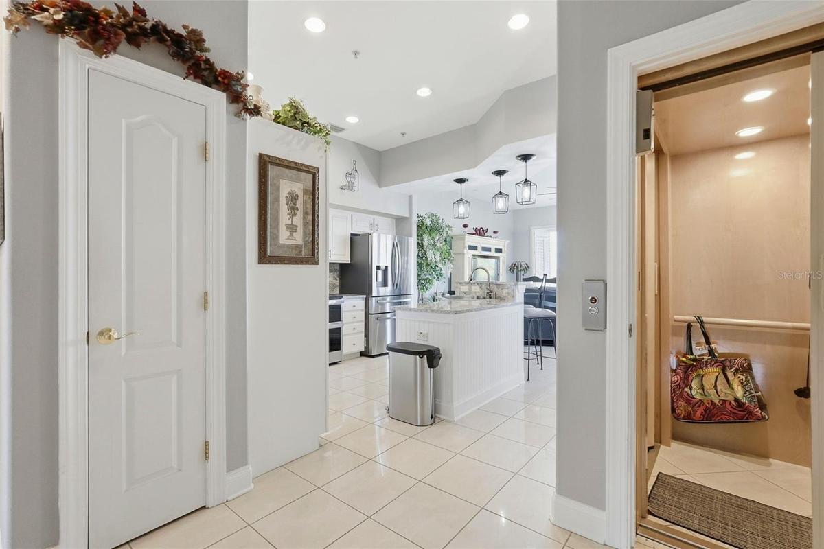 2nd level features high ceilings, a kitchen with an oversized quartz island opening into spacious waterfront living area with balcony and wide water v