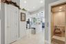 2nd level features high ceilings, a kitchen with an oversized quartz island opening into spacious waterfront living area with balcony and wide water v