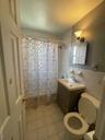 Full bathroom featuring light tile patterned flooring, vanity, tile walls, and shower / bath combo