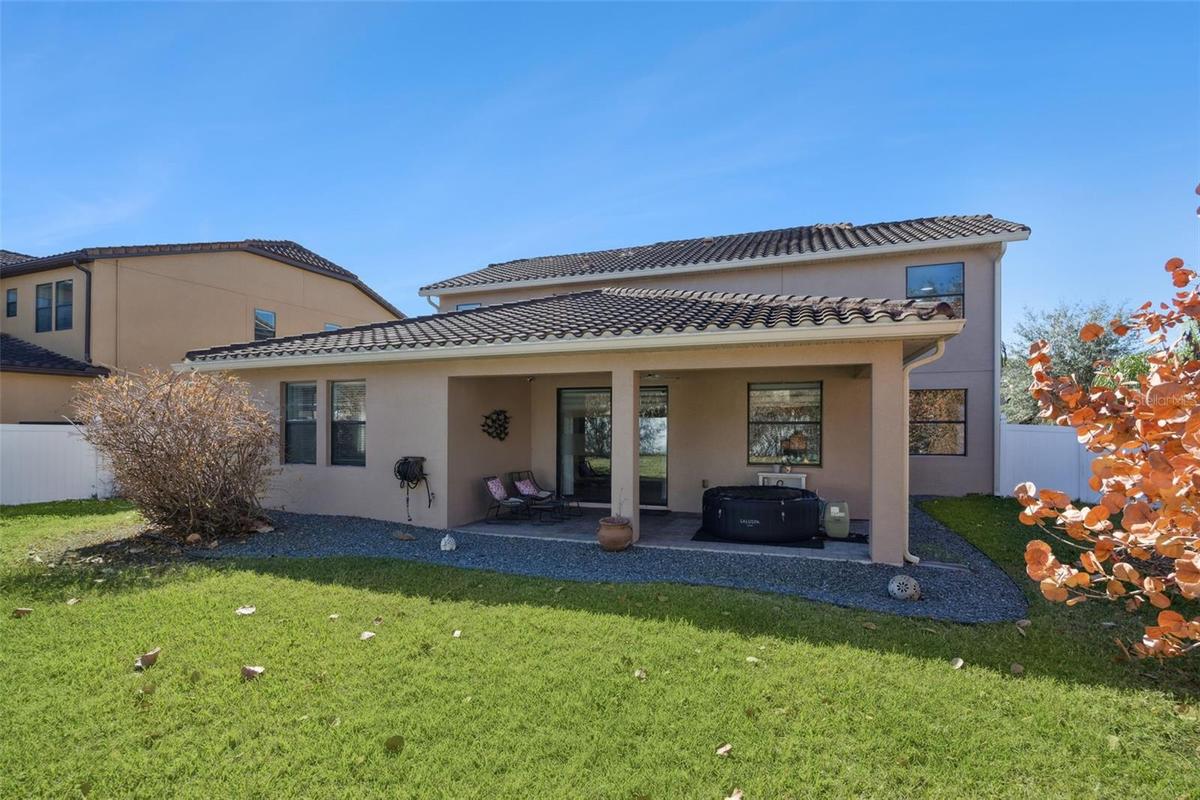 View of the back of this home with tile roof
