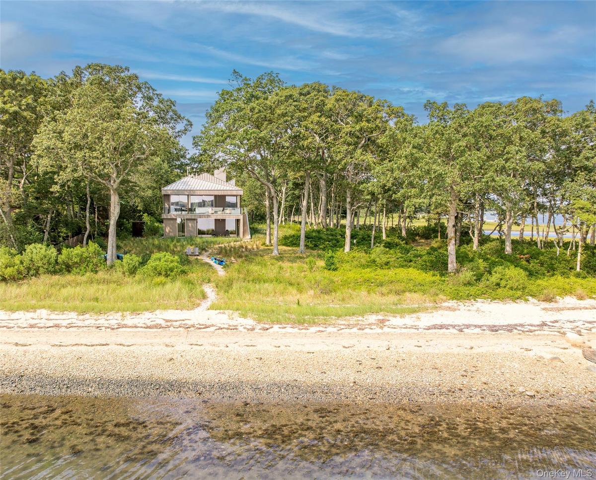 Beach home featuring a water view and a chimney