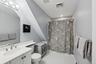 Bathroom featuring tile patterned floors, vanity, toilet, and walk in shower