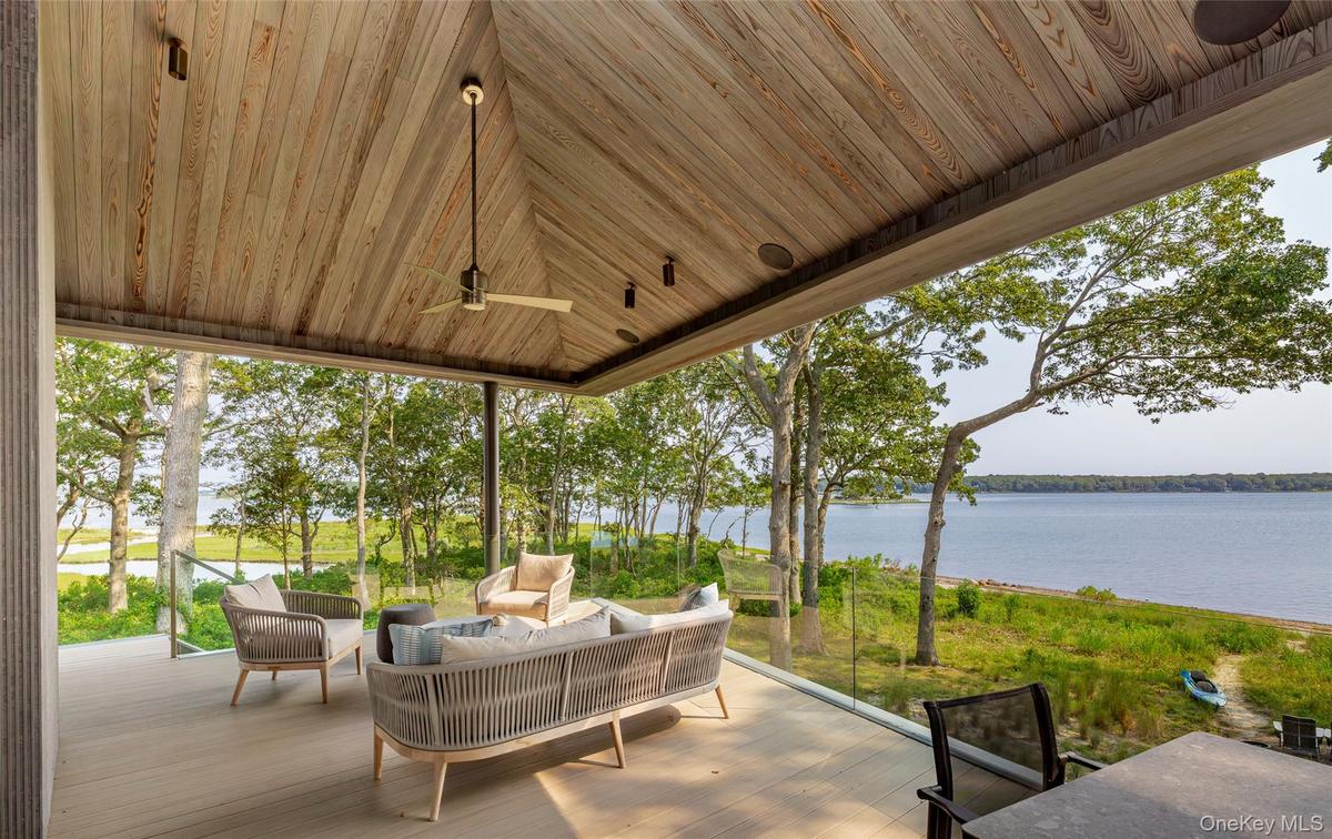 View of patio / terrace featuring an outdoor living space and a deck with water view