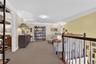 Living area featuring attic access, crown molding, and carpet