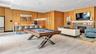 The game room features a billiards table, comfortable lounge seating, and a television for recreational and entertainment.
