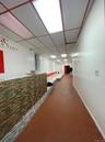 Corridor featuring a drop ceiling and brick flooring