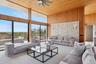 Living room featuring wood walls, wood ceiling, a high ceiling, and a ceiling fan