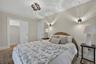 Bedroom with ceiling-mounted lighting fixture and two wall-mounted sconces